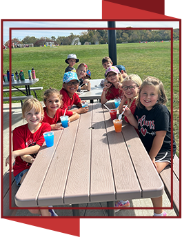 Students enjoying icee treats outside at a picnic table